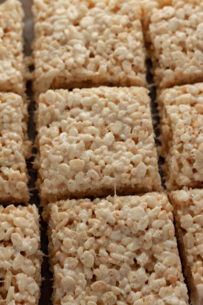 Coconut Rice Krispie treats cut into squares flat on a counter.