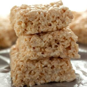 A stack of coconut rice krispie treats on a piece of wax paper.