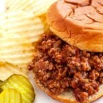 Chipotle sloppy joes with a side of potato chips and sliced pickles.