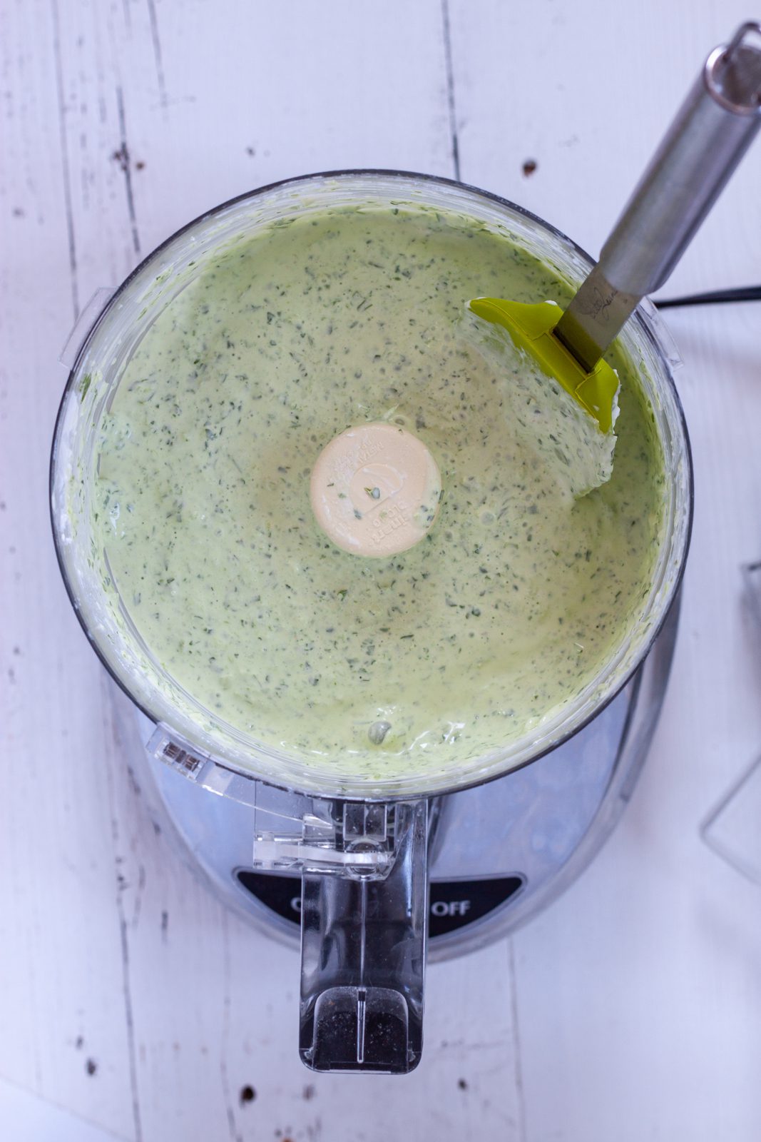 Green sauce in the food processor bowl after blending.