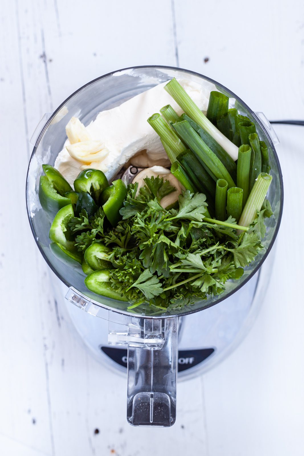 Ingredients to make green sauce in a food processor.