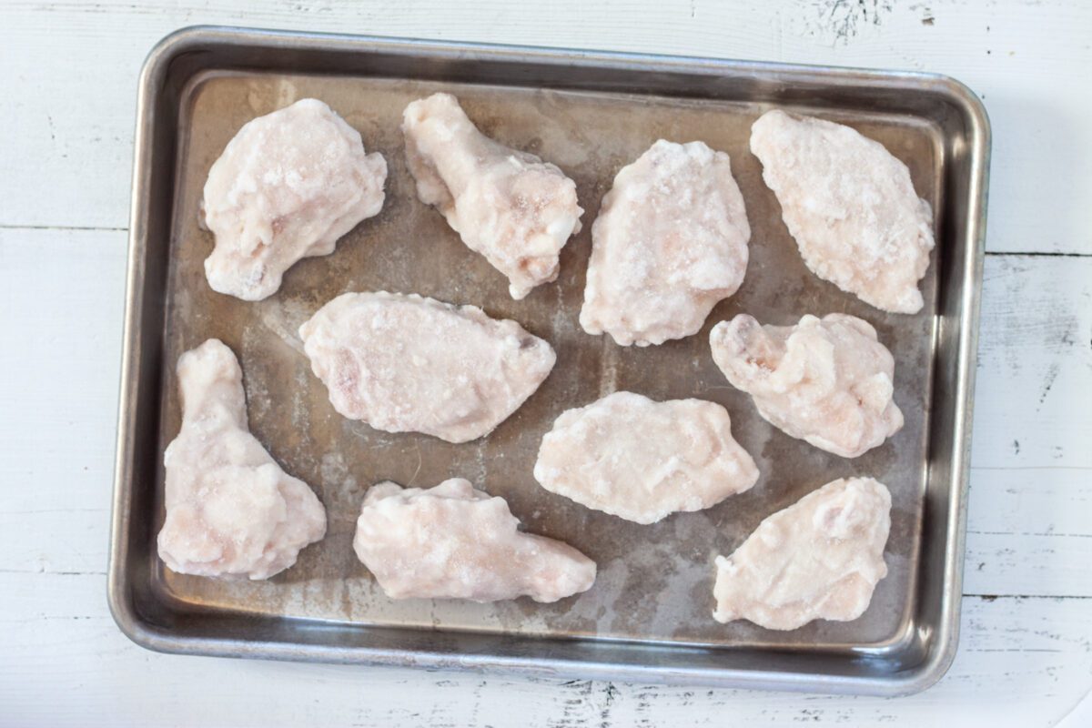 Frozen chicken wings on baking tray