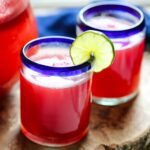 watermelon water in a glass with a lime wedge for garnish.