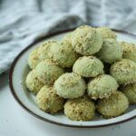 pistachio cookies piled on a plate.