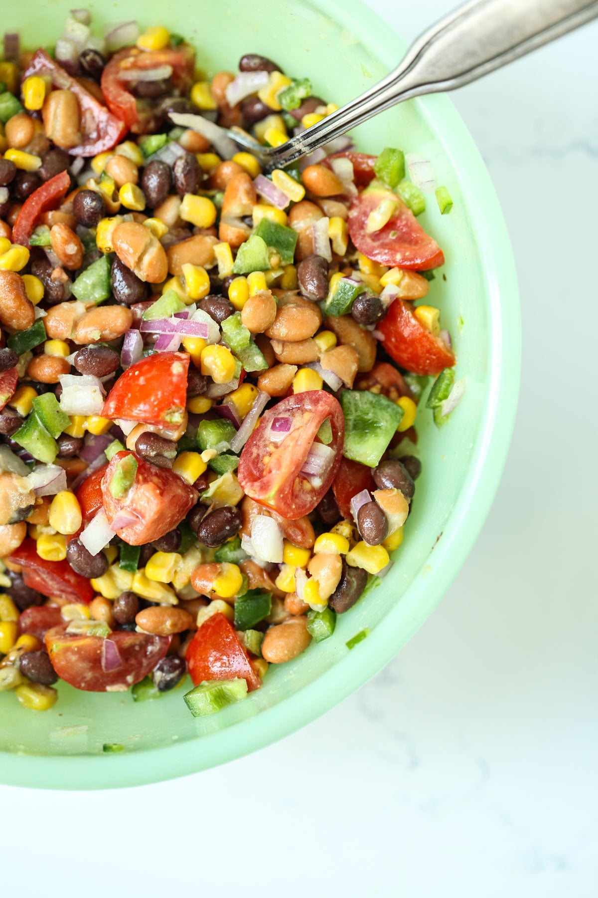 mexican bean salad freshly made in a green bowl.