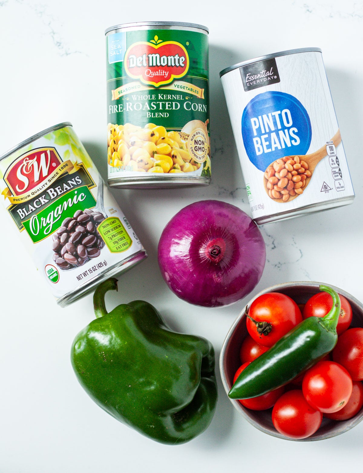 ingredients needed for mexican bean salad including pinto and black beans, corn, peppers, onion, jalapeno.