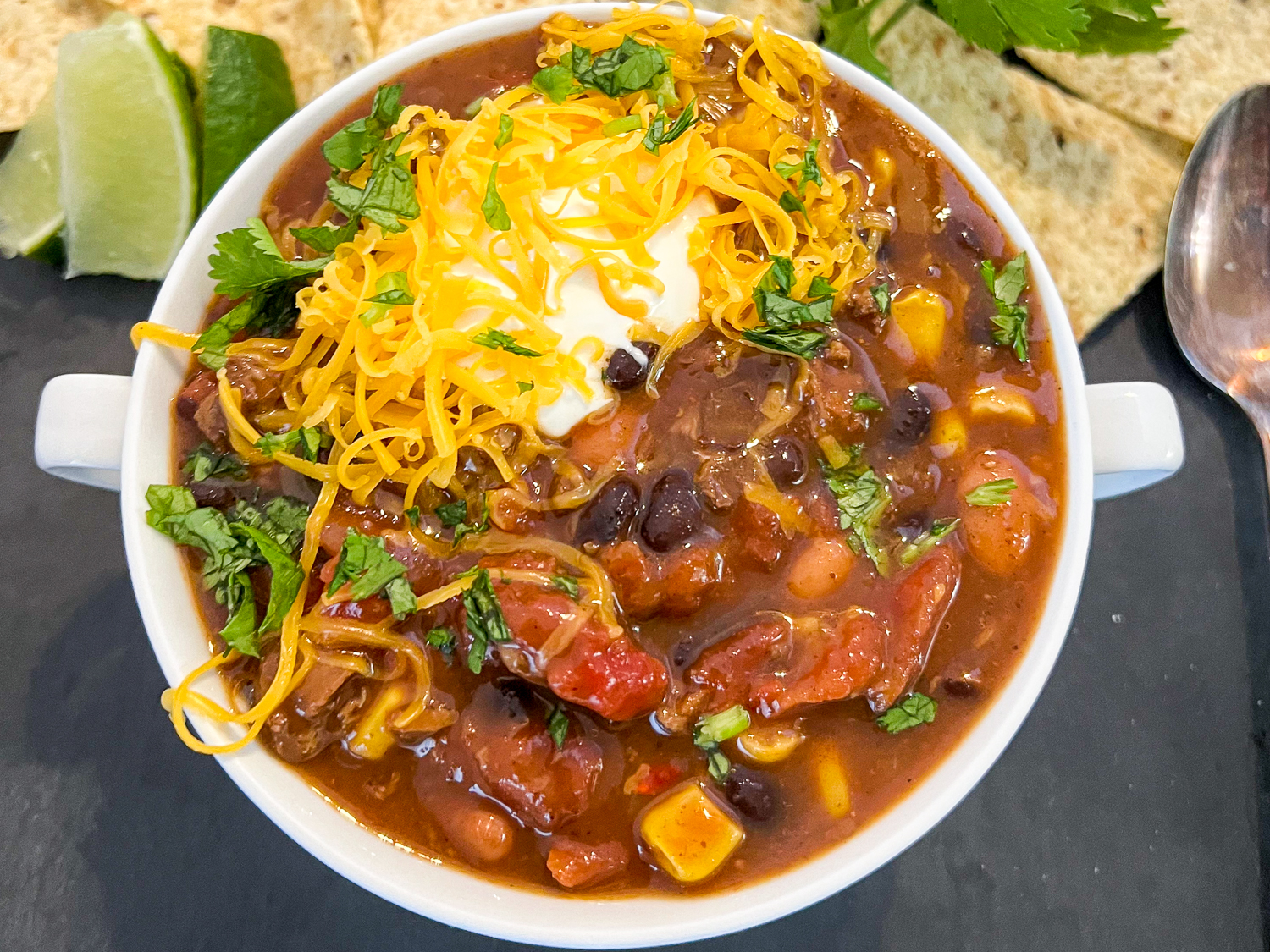 7 can soup made in a Dutch oven and topped with garnished including cheese.