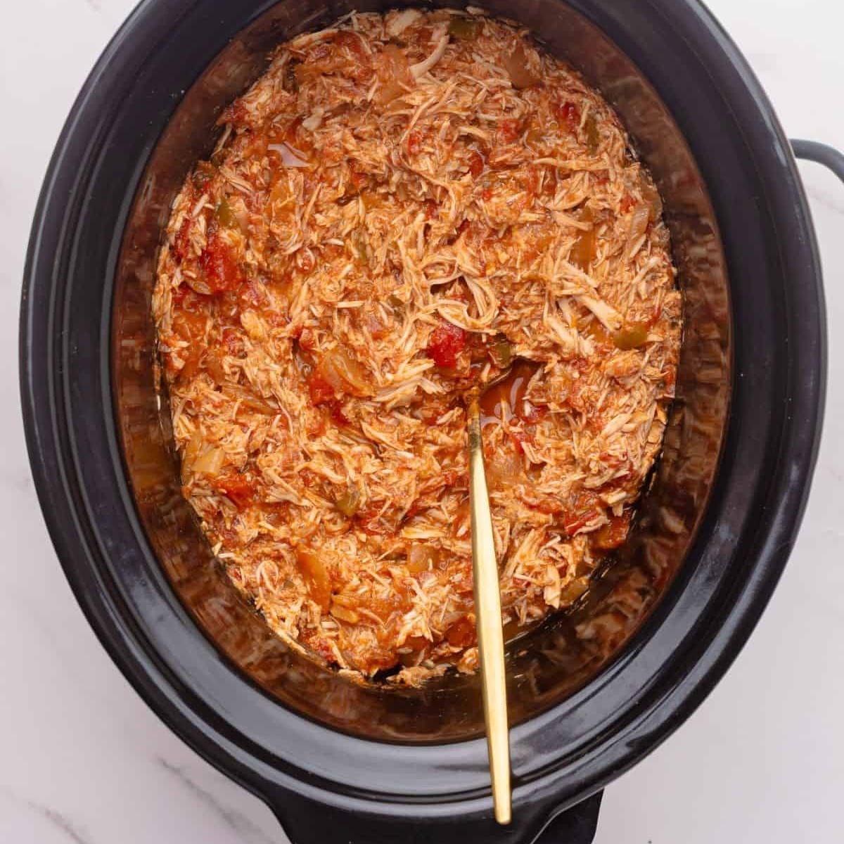 crock pot salsa chicken in a crock pot with a spoon