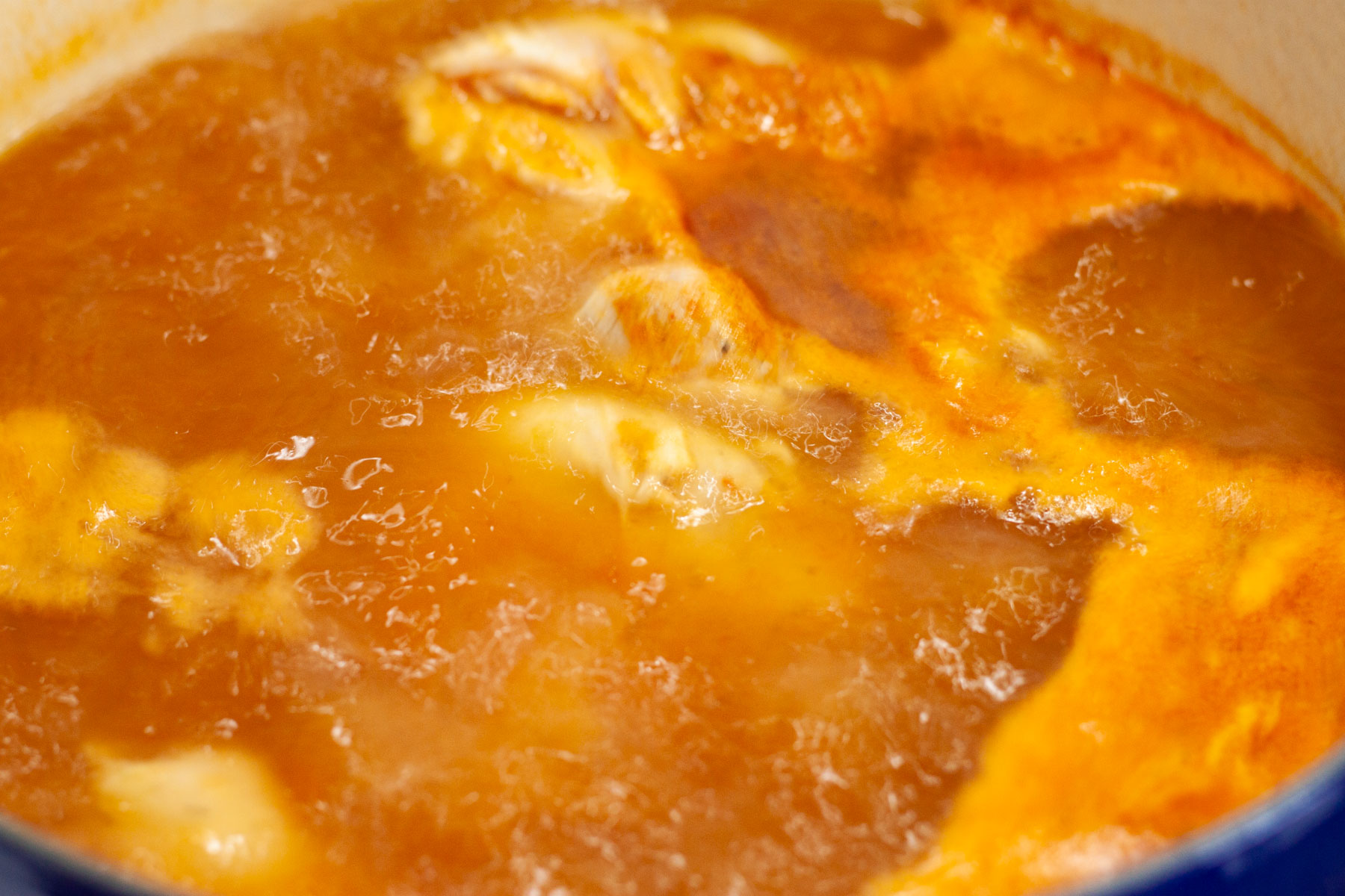 Chicken thighs cooking in chicken tortilla soup.