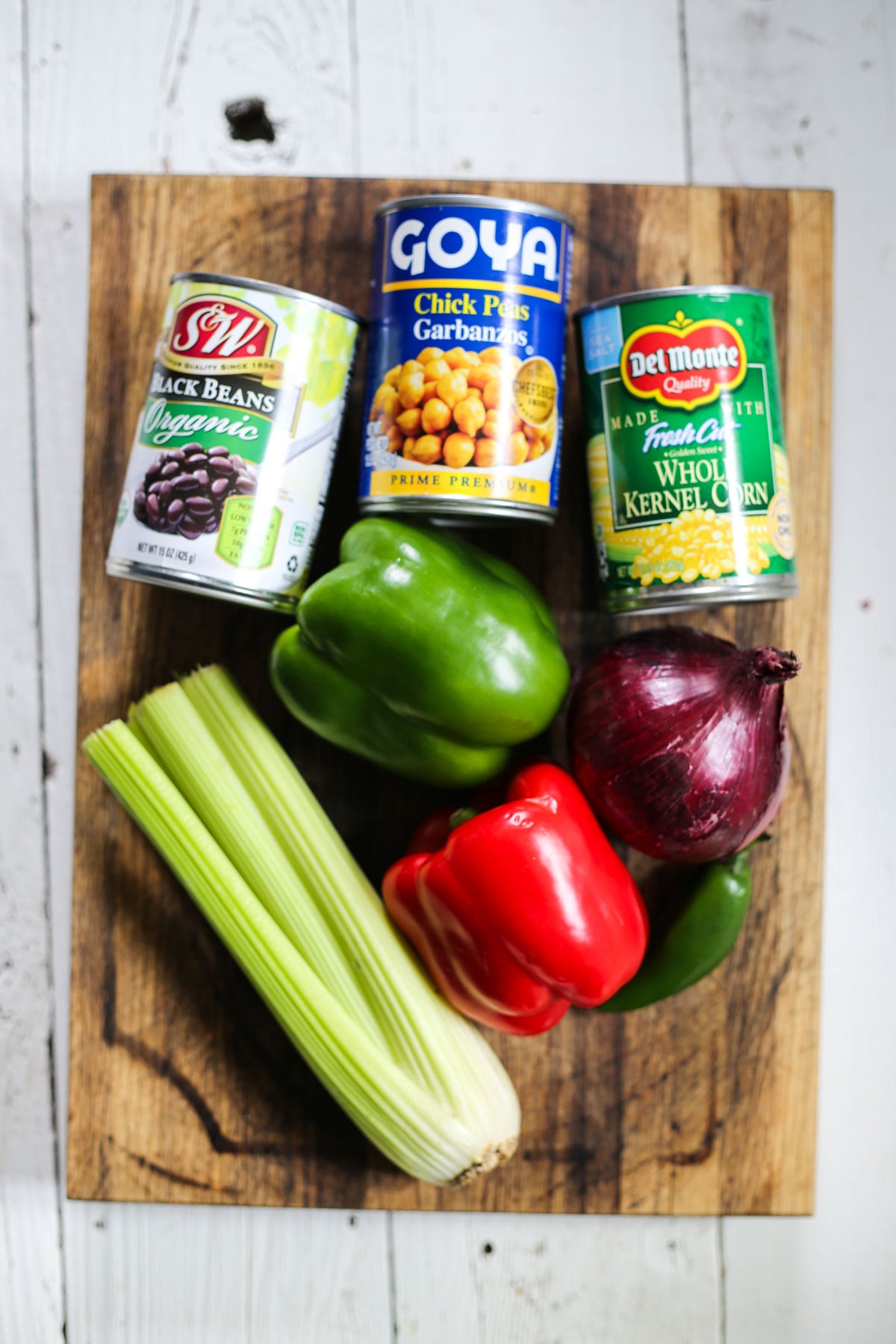 ingredients for marinated bean salad including caned corn, beans, bell pepper, celery, and onion.
