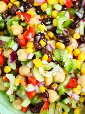 rainbow marinated bean salad in a green bowl.