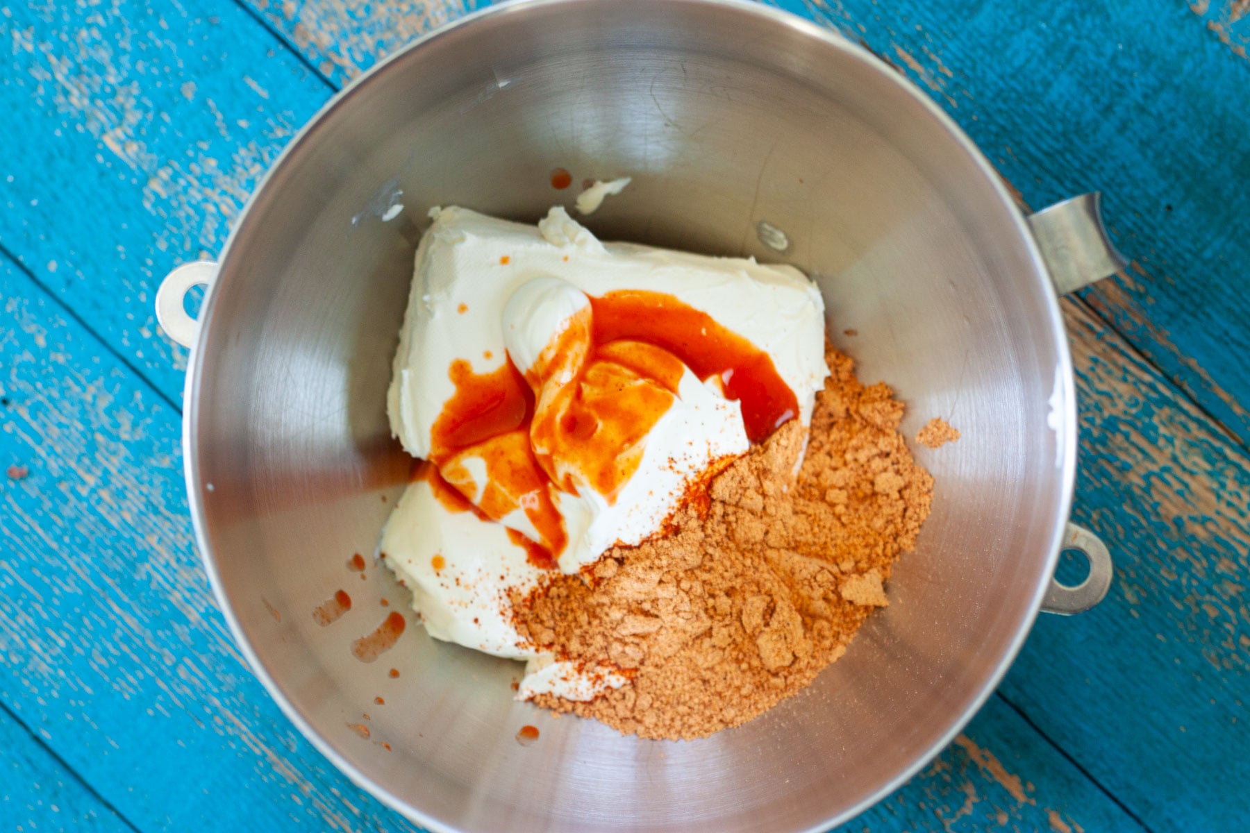 cream cheese, sour cream, hot sauce and taco seasoning in a large bowl and mix with a mixer.
