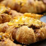 close up of a croissant tacos with melty cheese on a baking sheet
