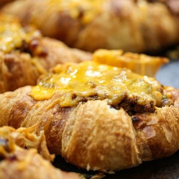 close up of a croissant tacos with melty cheese on a baking sheet