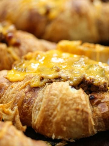 close up of a croissant tacos with melty cheese on a baking sheet